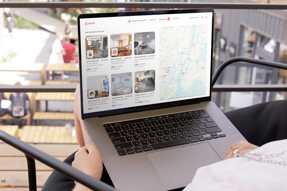 Person browsing vacation rental listings on Airbnb on a laptop